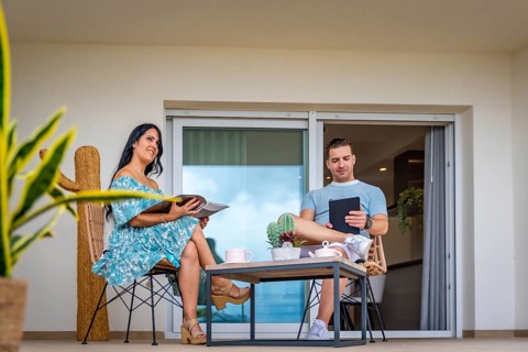 Daydreaming of a couple reading and using tablet drinking coffee in the patio
