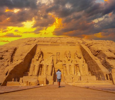 A young man walking towards the Abu Simbel Temple in southern Egypt in Nubia next to Lake Nasser.