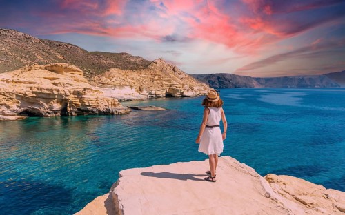 A young woman in a white dress looking at the sea in Rodalquilar in Cabo de Gata on a beautiful