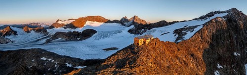 Atmospheric sunrise in a picturesque mountain landscape, alpenglow, aerial view, mountain hut
