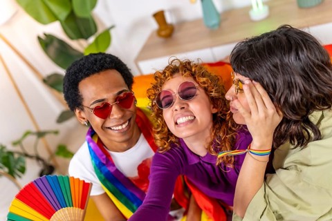 Multi-ethnic and non binary friends having fun together celebrating lgbt pride at home