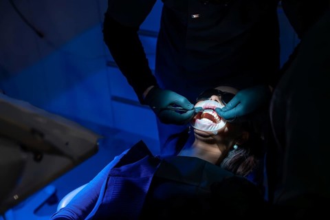 Dentist applying whitening gel on patient's teeth, enhancing oral health and creating a radiant,