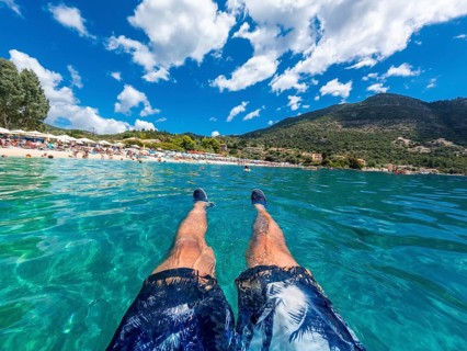 A man resting in the sea on the beach in summer of Paralia Mikros Gialos in the south of the island