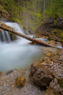 A tree trunk lies across a waterfall, long exposure, Dolomites, Puez-Geisler nature park Park, St.