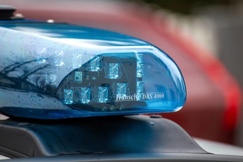 Symbolic image of a police operation: close-up of a flashing blue light on a police car