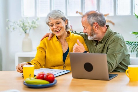 Senior man congratulating his wife for an announcement that she received online