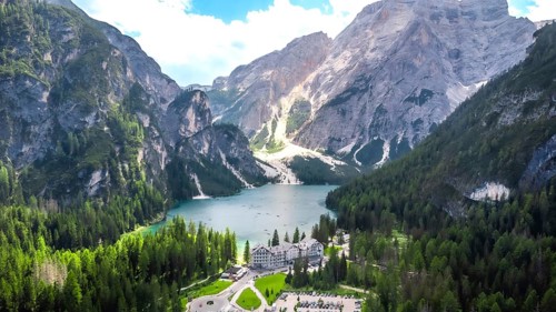 Stunning aerial view of lake braies with the iconic seekofel mountain and a charming hotel nestled