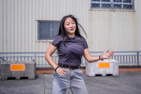 Female asian young artist dancing K-pop korean dance alone in the city