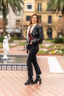 Fashionable woman standing in urban park, showcasing her trendy outfit and enjoying the pleasant