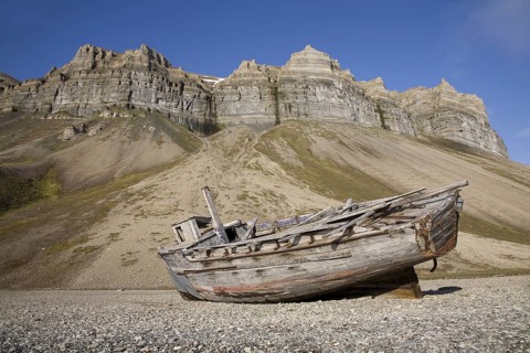 Wooden wrecked fishing boat stranded on shingle beach of Skansbukta, Svalbard, Spitsbergen