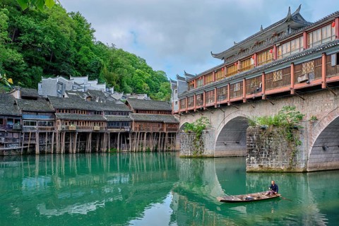 FENGHUANG, CHINA, APRIL 23, 2018: Unidentified chinese man in boat Feng Huang Ancient Town (Phoenix