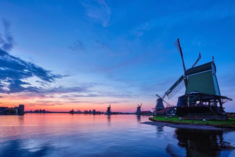 Netherlands rural scene, windmills at famous tourist site Zaanse Schans in Holland on sunset with