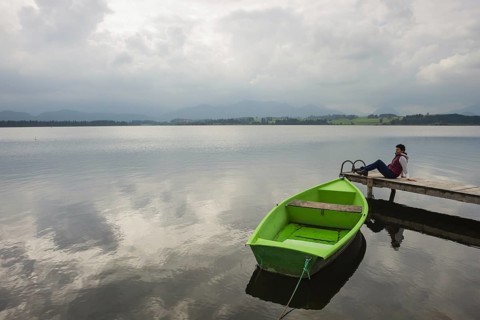 Woman 50-55, wooden jetty, green rowing boat, Hopfensee, Hopfen am See, near Füssen, Ostallgäu,