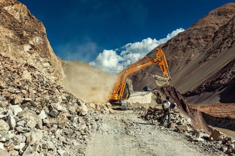 LADAKH, INDIA, SEPTEMBER 10, 2011: Excavator cleaning road after landslide in Himalayas. Ladakh,