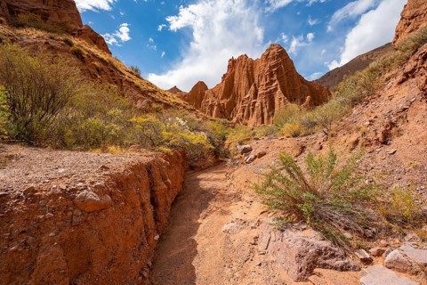 Eroded mountain landscape with sandstone cliffs, canyon with red and orange rock formations,