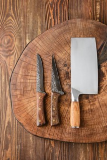 Top view of cleaver and knives on wooden stump