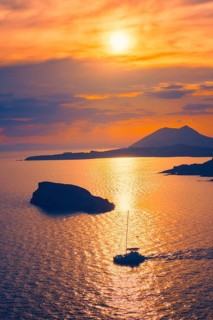 Aegean Sea with Greek islands view on sunset with yacht in sea. Cape Sounion, Greece, Europe