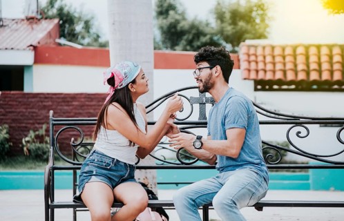 Young couple arguing sitting on a park bench, Concept of aggressive couples in the park. Upset
