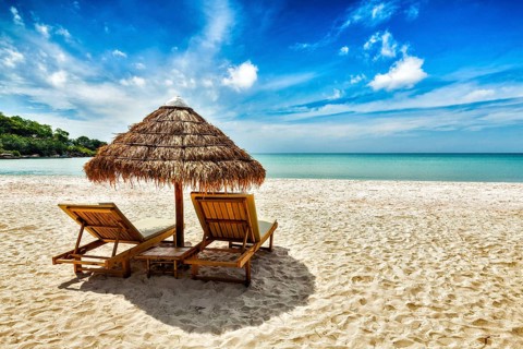 Vacation holidays background wallpaper, two beach lounge chairs under tent on beach. Sihanoukville,