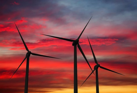Green renewable energy concept, wind generator turbines in sky on sunset