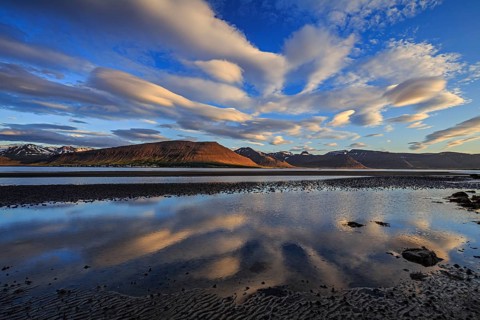 Ebb pond at a fjord off Bergen, evening light, clouds reflected in the water, Westfjords, Iceland,