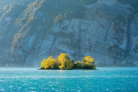 Small chive island in the turquoise waters of Lake Walen, Canton St. Gallen, Switzerland, Europe