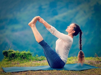 Yoga exercise outdoors, woman doing Ashtanga Vinyasa Yoga balance asana Ubhaya padangusthasana Big