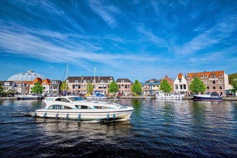 HAARLEM, NETHERLANDS, MAY 6, 2017: Boats and houses on Spaarne river with blue sky. Haarlem,