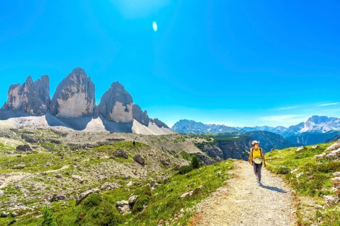 Tourist walking on a mountain path near tre cime di lavaredo, a symbol of the dolomites, a unesco