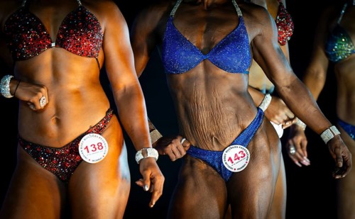Female bodybuilders pose on stage as they compete the 4th Ms Saraighat all India classic body