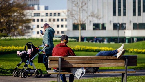A couple relaxing on a park bench in the city garden in times of the corona crisis, Essen, Ruhr