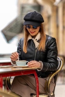 Tourist savoring a cappuccino at an outdoor cafe in bordeaux, france, enjoying the charming