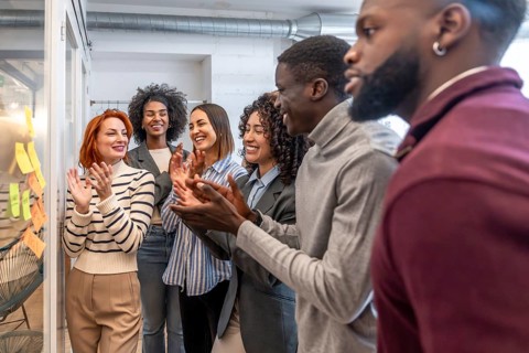 Diverse colleagues applauding at the end of creative brainstorming process in a coworking space