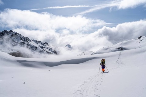 Atmospheric clouds in a wintry mountain landscape, ski tourer on the ascent to Porta d'Es-cha,