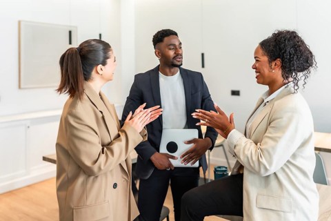 Business colleagues clapping and discussing during a productive meeting in a modern office