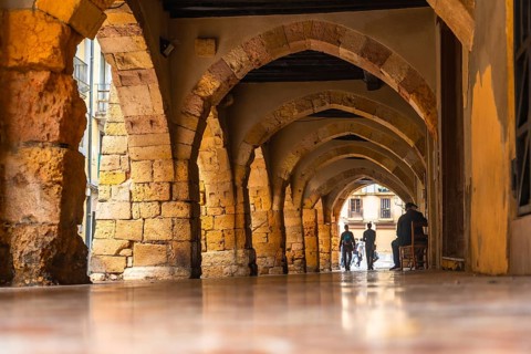 Tourists walking through the arches of the medieval city of tarragona, spain, enjoying the