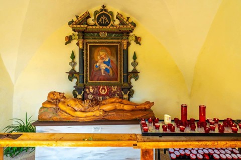 Reclining wooden statue of jesus christ and painting of madonna with child inside the santa