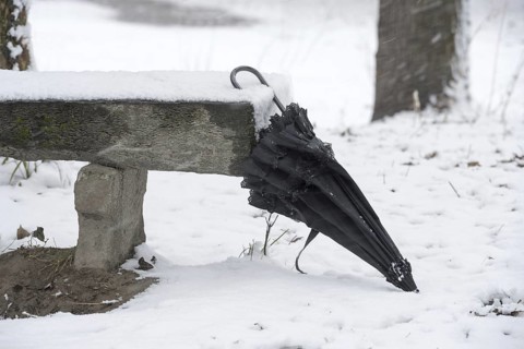 Umbrella Leaning on a Bench with Snow in Winter in a Park in Locarno, Ticino, Switzerland, Europe