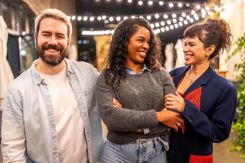 Multi-ethnic millennial friends smiling standing on night bar terrace celebrating a party