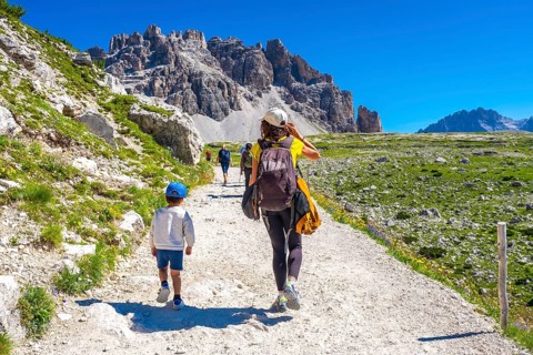Tourists walking on a sunny summer day on the trail around tre cime di lavaredo in the dolomites