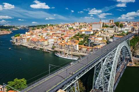 View of Porto city and Douro river with moored sailing ship and Dom Luis bridge I from famous