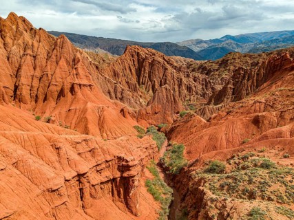 Eroded mountain landscape, canyon with red and orange rock formations, aerial view, Konorchek