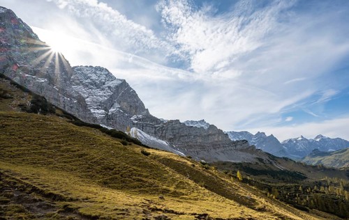 Mountain landscape with yellow meadows in autumn, summit Lamsenspitze with sun star, Karwendel,
