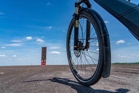 Cycling in the Ruhr area, on the Schurenbach slag heap, Bramme landmark for the Ruhr area by artist