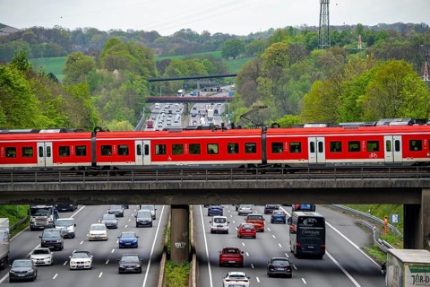 S-Bahn train crossing the motorway A3, traffic on 8 lanes, incl. the temporarily released hard