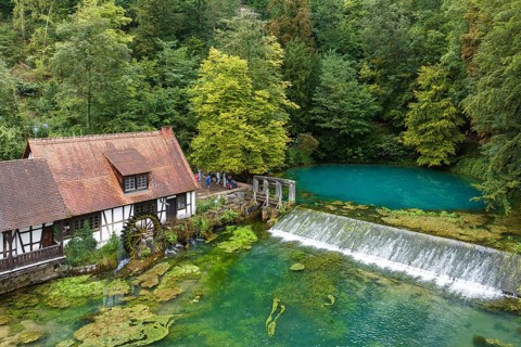 Blautopf Blaubeuren with industrial monument Hammerschmiede, source of the little river Blau in a