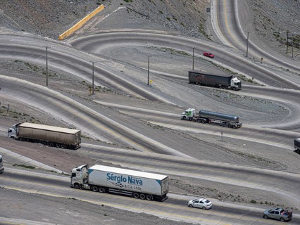 Heavy traffic of trucks on mountain pass Los Caracoles, The Snails, road connecting Chile and