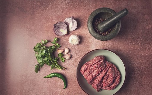 Fresh minced meat, raw, with spices and ingredients. on the table, preparation, top view