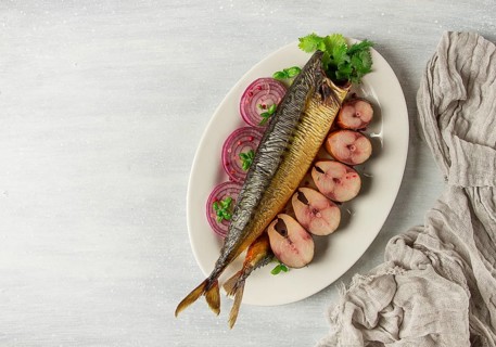 Smoked mackerel, top view, with spices, on a wooden table, no people, selective focus
