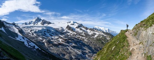 Mountaineer on a hiking trail, view of high alpine mountain landscape, summit of Aiguille de